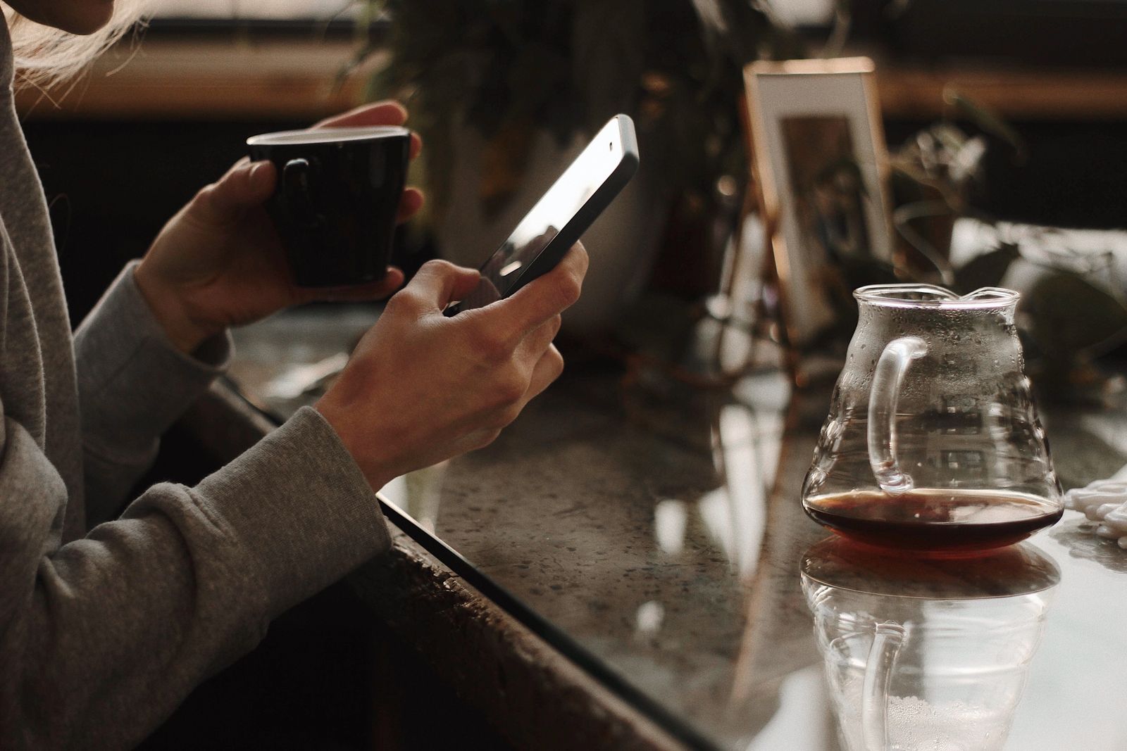 A person using a smartphone at a cafe